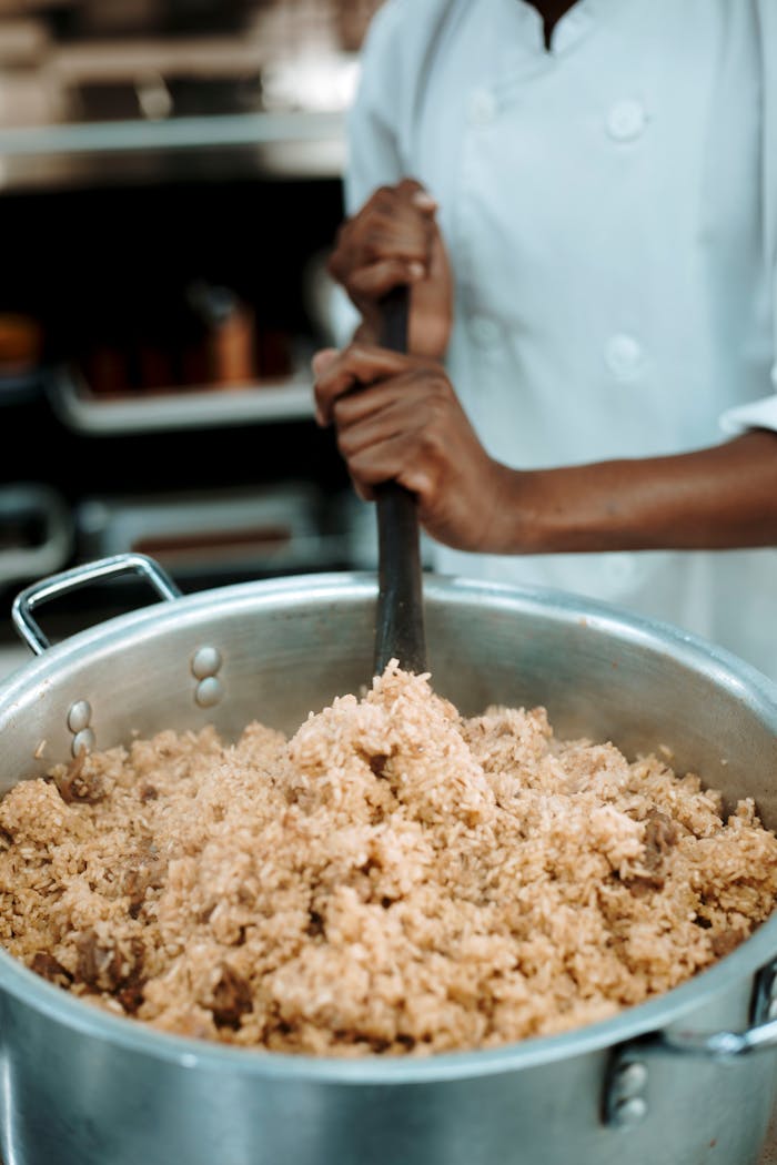 chef-stirring-large-pot-of-steaming-rice-dish-33004274